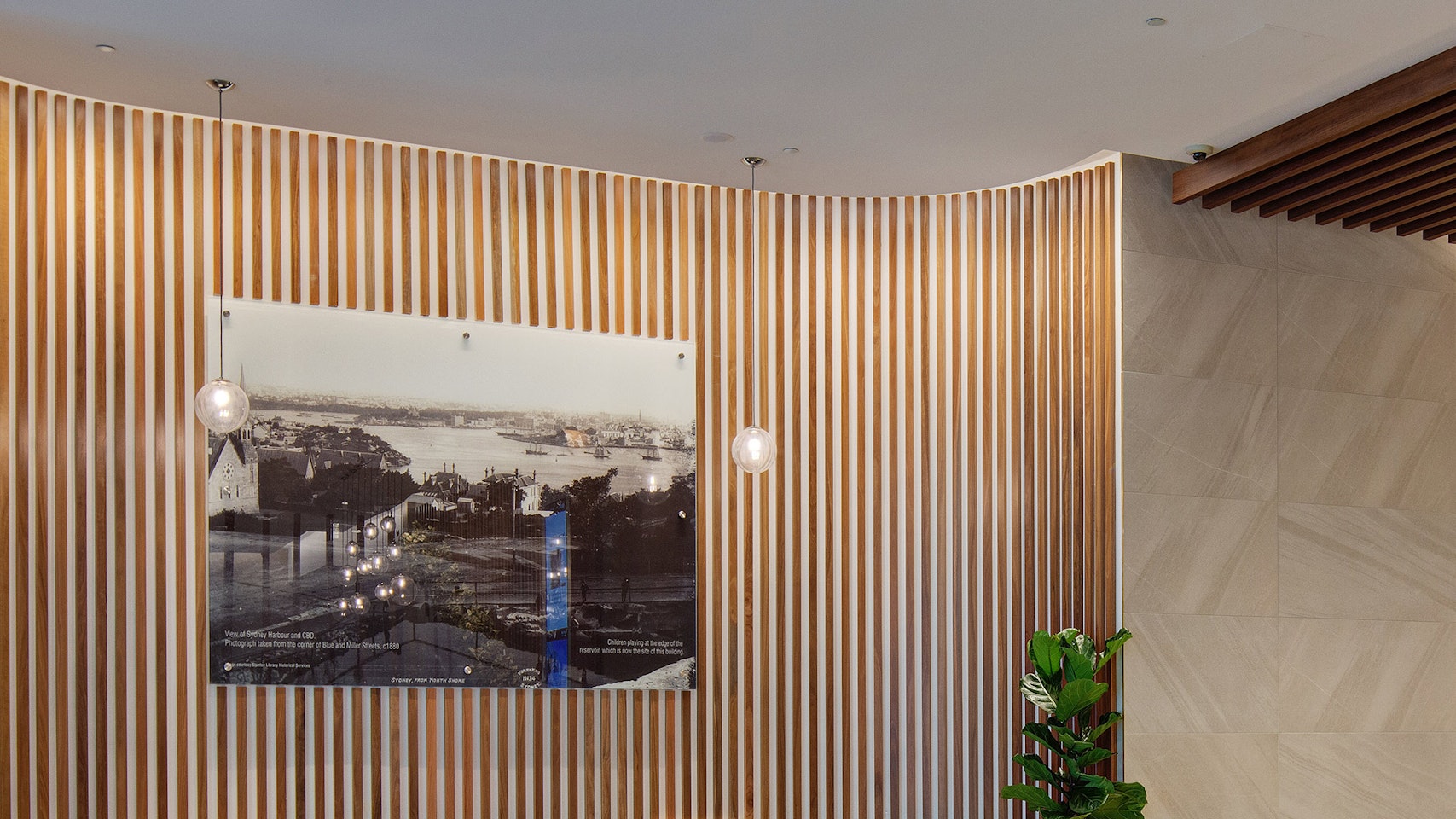 Precise illumination of the lobby features at 40 Miller Street, including grazing timber panelling on curved walls with Aduro CL.