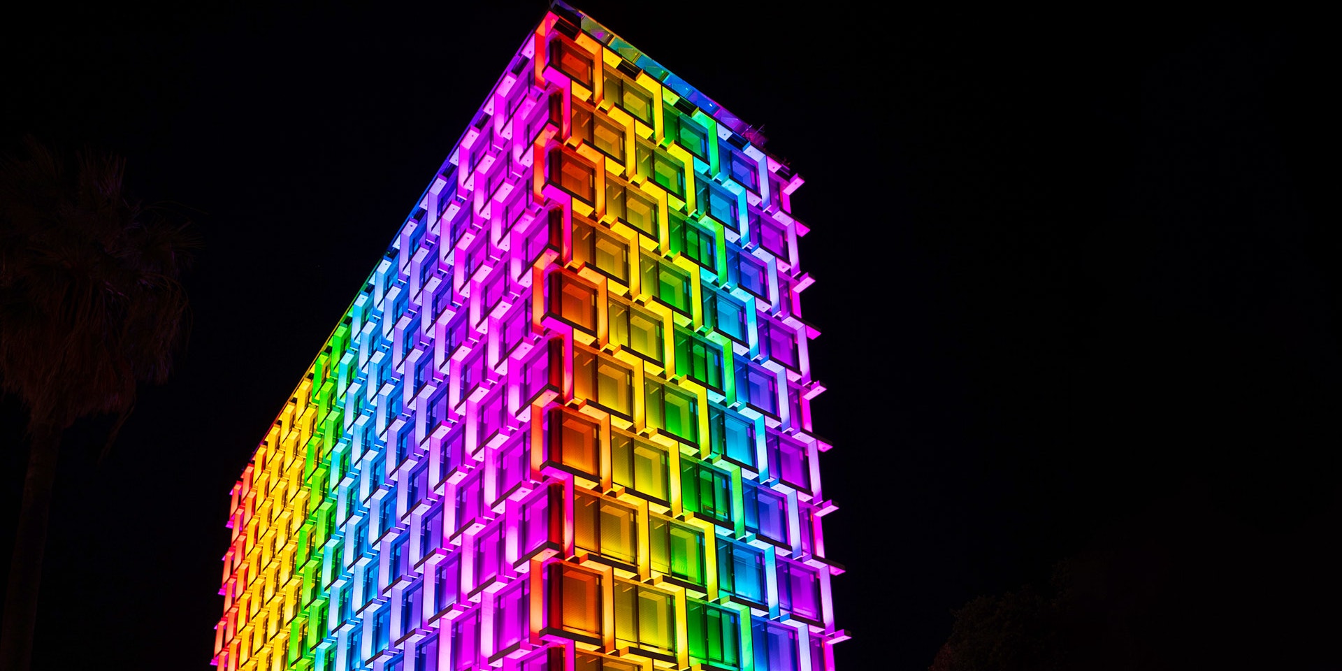 Latitude LED luminaire in application, installed on the facade on Council House in Perth. Colour changing feature is illustrated, the building is illuminated in rainbow colours. 