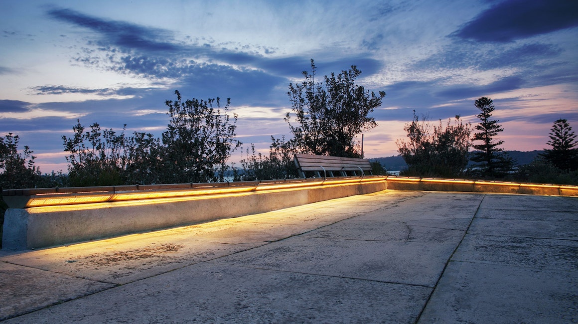 Gap Park in Watsons Bay, NSW features an installation of side-emitting strip lighting to create a continuous warm white glow under the bench seating.