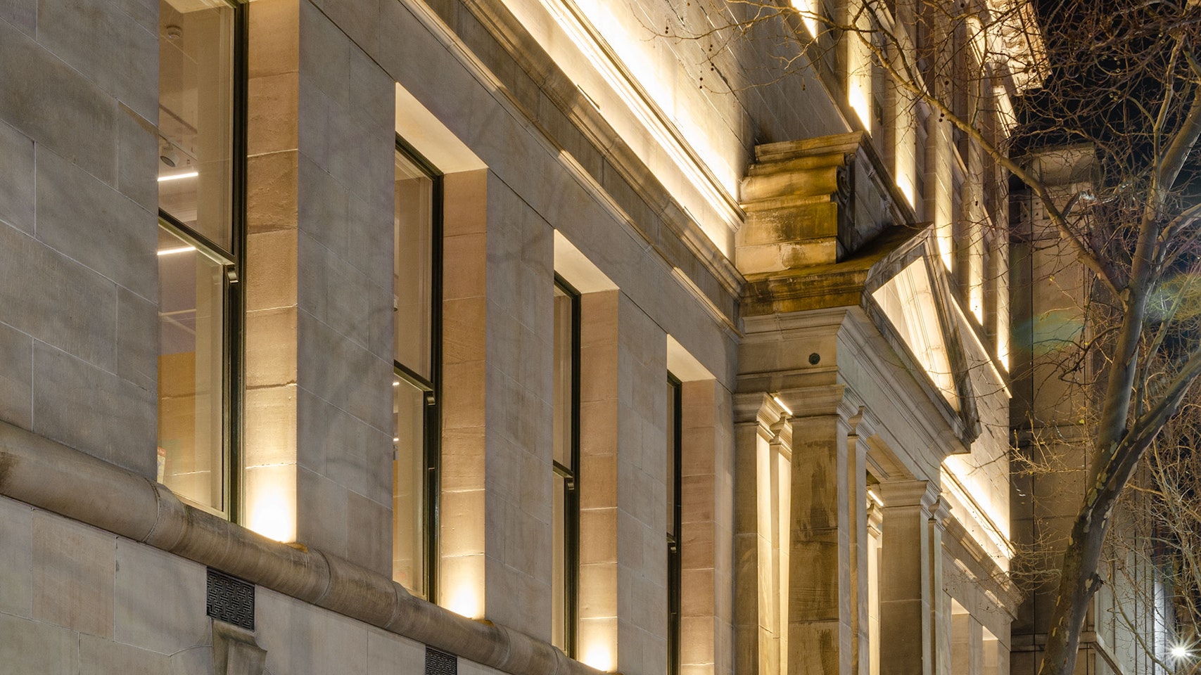 Max Mini IP LED luminaire in application. Discreet Max Mini IP linear floodlights highlight the façade at Melbourne State Library of Victoria. View on the facade from the side.
