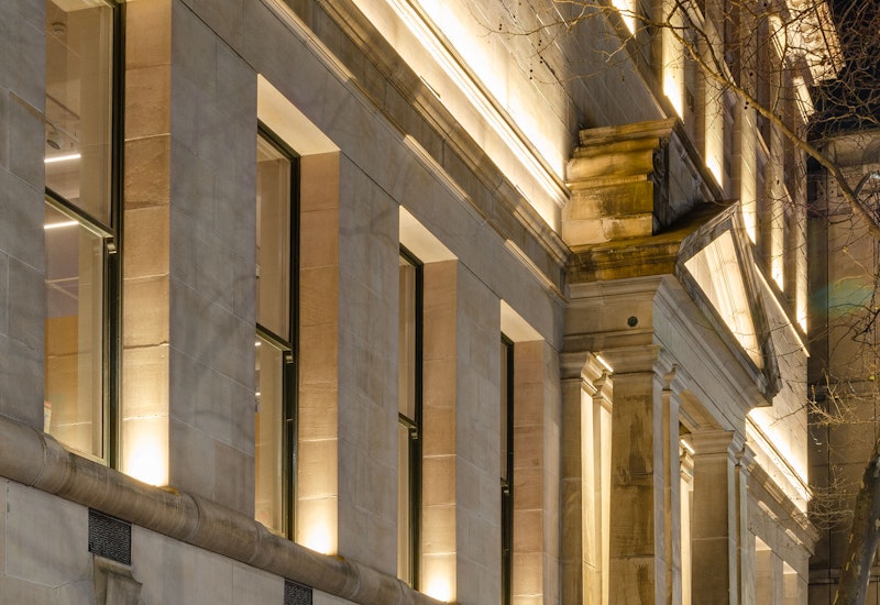 Max Mini IP LED luminaire in application. Discreet Max Mini IP linear floodlights highlight the façade at Melbourne State Library of Victoria. View on the facade from the side.
