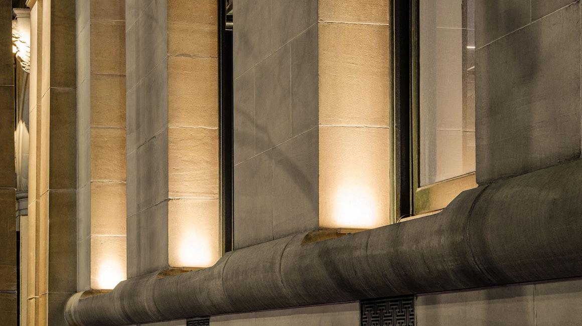 Max Mini IP LED luminaire in application. Discreet Max Mini IP linear floodlights highlight the façade at Melbourne State Library of Victoria. Close up on the columns.