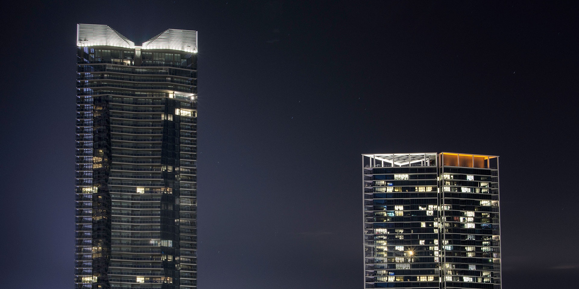 Maxis high-power linear flood light  in application, installed on Yarra Point (Tower 6). Maxis high-powered projector luminaires, complete with flare optics, are used to illuminate the architectural crown of the building.